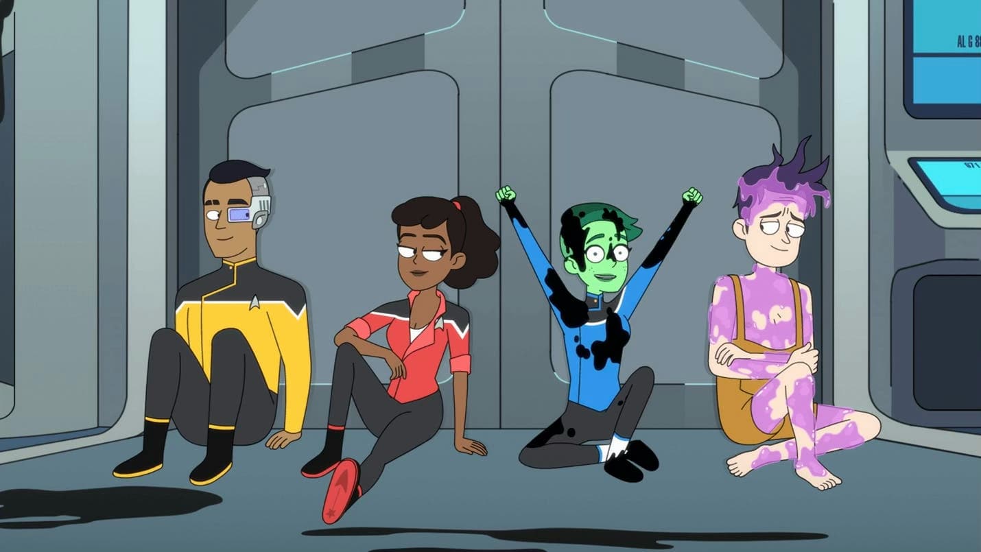 Rutherford, Mariner, Tendi, and Boimler sit together on the floor of a ship corridor, with Tendi and Boimler covered in dark and purple goo, celebrating after a mission.