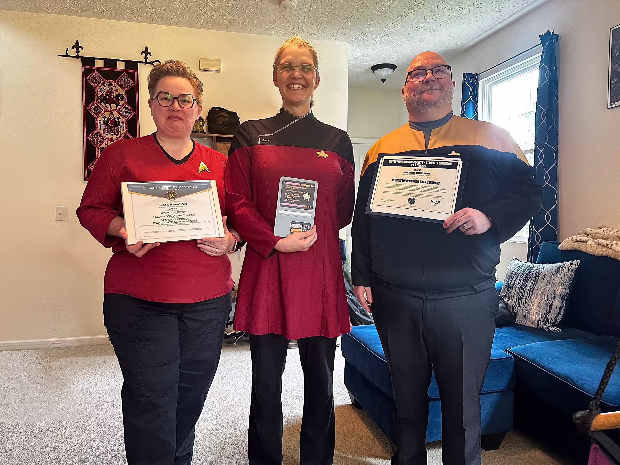 Lieutenant Commander Sterling awarding promotions and commendations to two crew members at the USS Terminus Star Trek club recommissioning ceremony